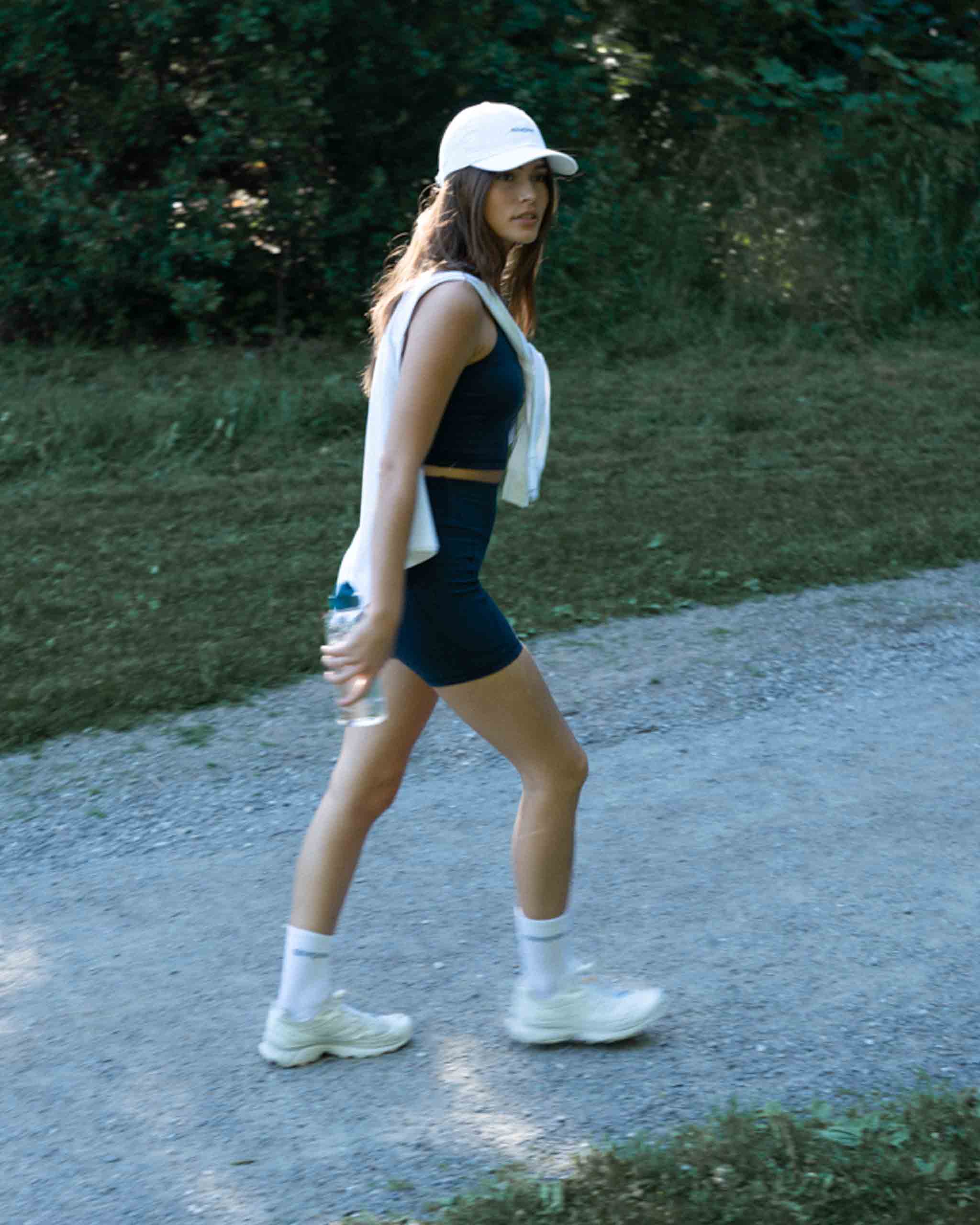 Girl in ninepine activewear outfit walking on a gravel track