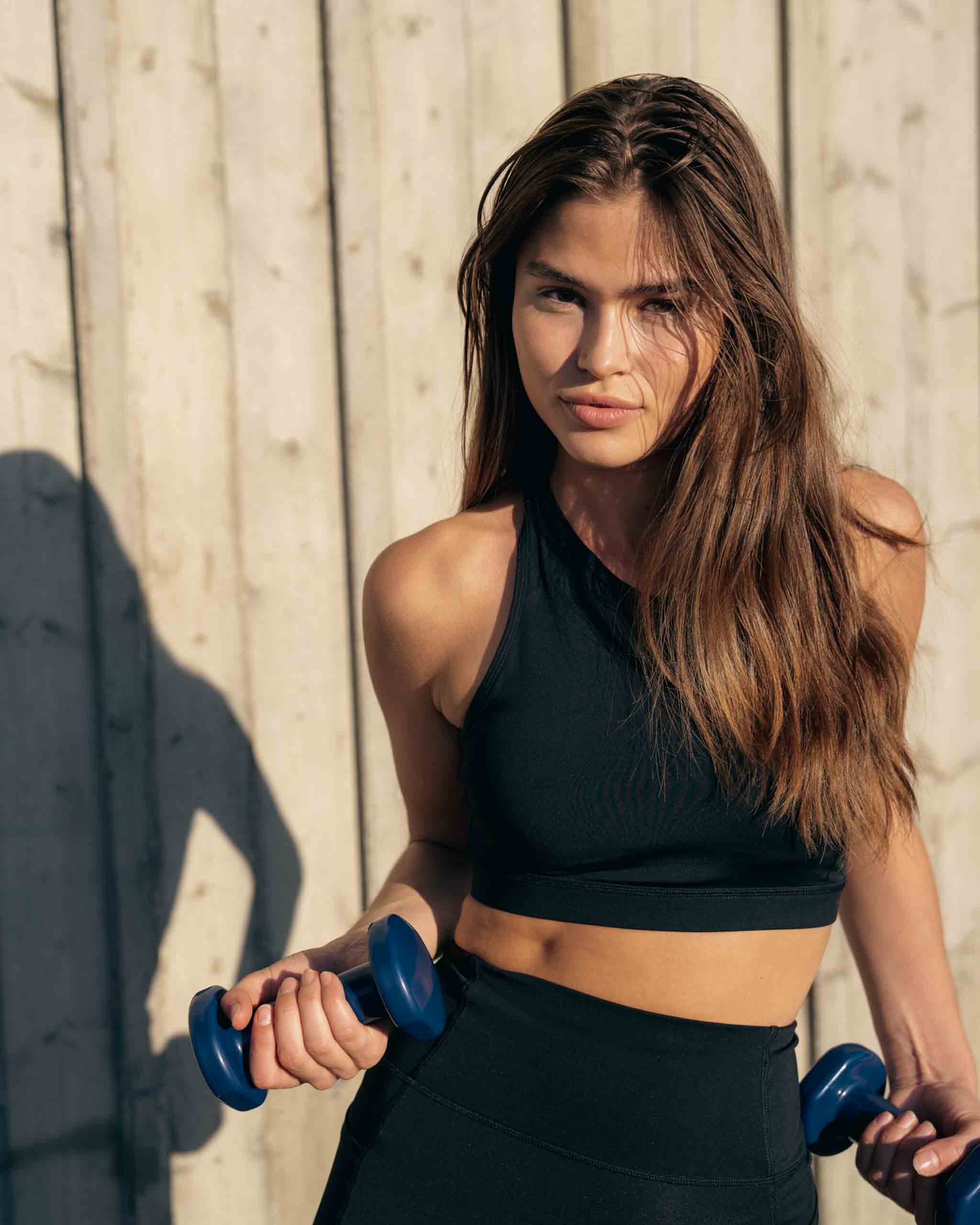 Girl in ninepine AM2.0 set posing with dumbbells