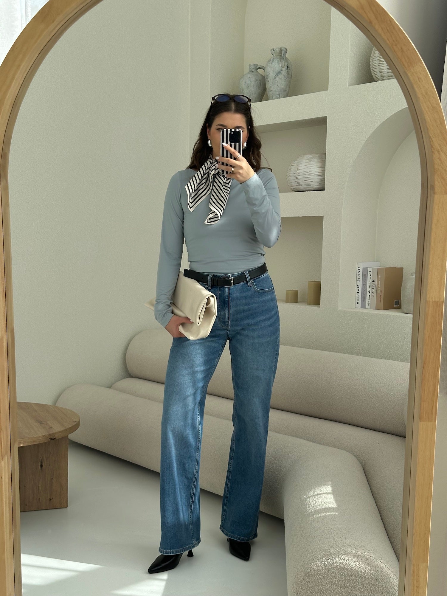 Woman wearing Ninepine ComfortDenim jeans in mid blue with soft long sleeve top in dusty blue, styled as a clean everyday outfit.
