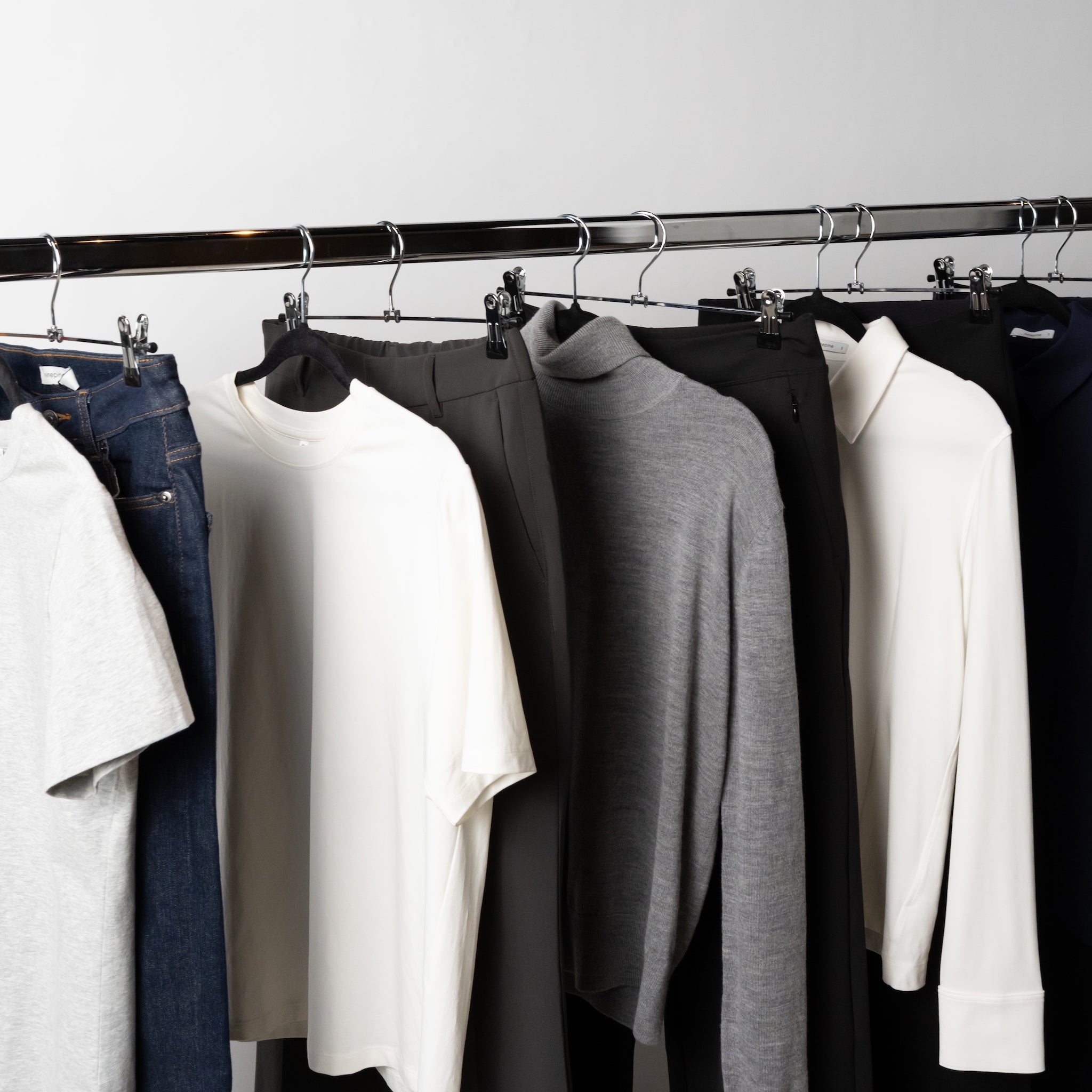 Garments hanging on a rack representing fabrics used in Ninepine clothing.