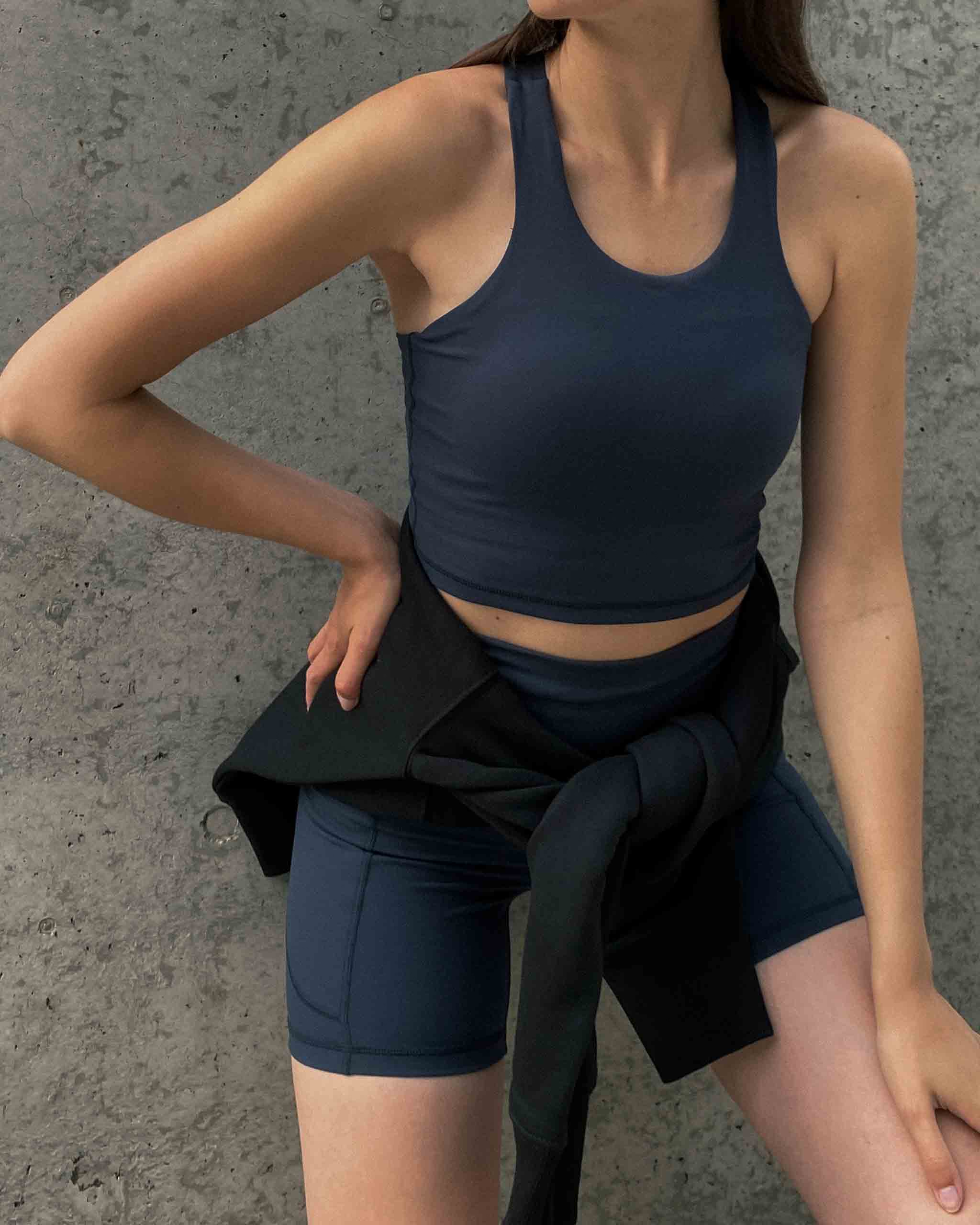 Frau posiert in Shorts und Tanktop von Ninepine Activewear